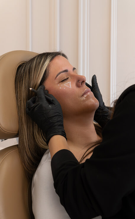 Facial balancing markings on woman’s face with white cosmetic pencil