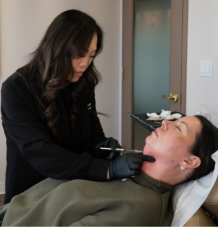 Practitioner performing belkyra fat dissolving injection under chin at the symm label in Calgary