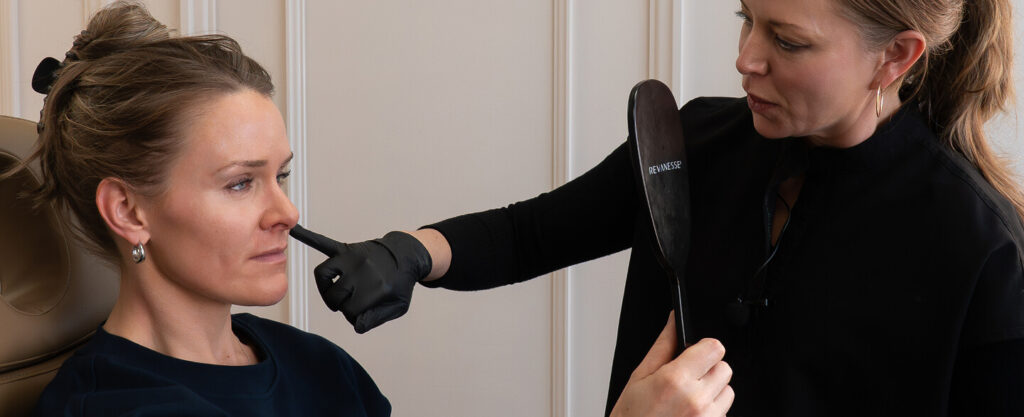 Practitioner assessing facial features during consultation at the symm label in Calgary