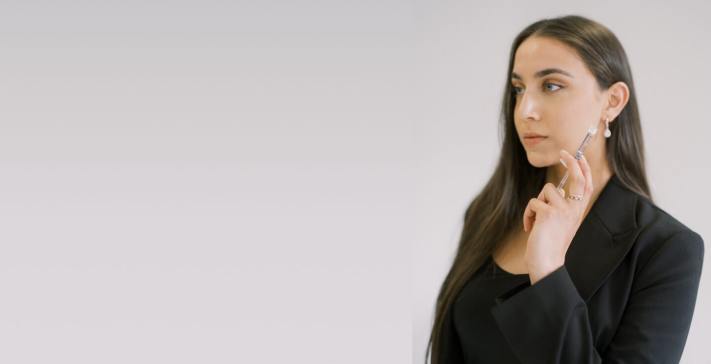 Woman holding syringe during facial balancing consultation at the symm label in Calgary