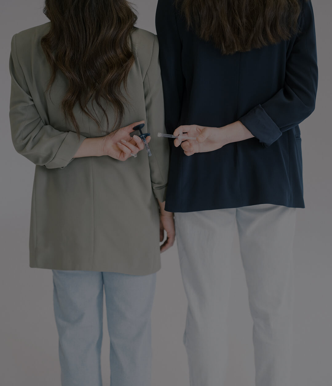 Practitioners holding injectable treatment syringes at the symm label in Calgary