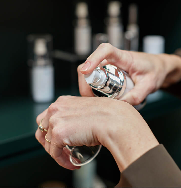 Hands pumping medical grade skincare product at the symm label in Calgary
